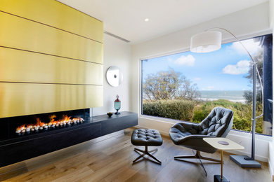 Photo of a contemporary open concept living room in Melbourne with white walls, medium hardwood floors, a ribbon fireplace and brown floor.