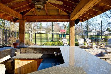 Inspiration for a large backyard stone patio kitchen remodel in Columbus with a gazebo