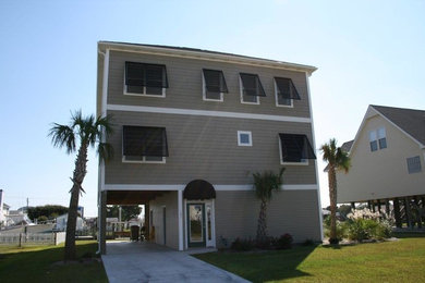 Large coastal gray three-story exterior home idea in Other with a shingle roof