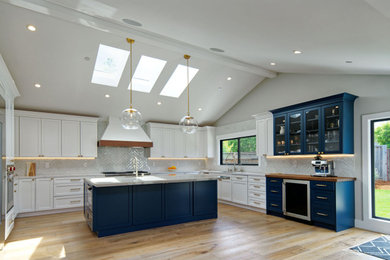 Large minimalist u-shaped light wood floor, vaulted ceiling and multicolored floor open concept kitchen photo in San Francisco with an undermount sink, shaker cabinets, quartzite countertops, blue backsplash, ceramic backsplash, stainless steel appliances, an island, white cabinets and white countertops