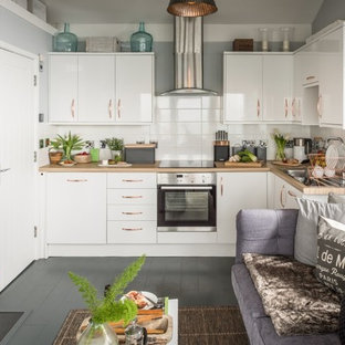 Imagen de cocina en L, contemporánea, pequeña, abierta, con fregadero integrado, armarios con paneles lisos, puertas de armario blancas, encimera de madera, salpicadero blanco, salpicadero de azulejos de cerámica, electrodomésticos de acero inoxidable, suelo de madera pintada y suelo gris