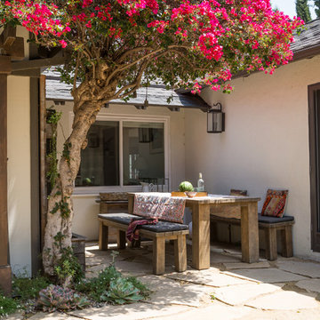 Casual outdoor dining area next to house with bougainvillea