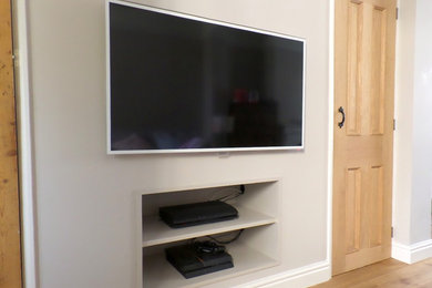 Inspiration for a contemporary living room in Essex with grey walls, medium hardwood flooring and a wall mounted tv.