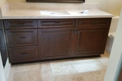 Inspiration for a mid-sized transitional master beige tile and porcelain tile alcove shower remodel in Los Angeles with raised-panel cabinets, dark wood cabinets, a two-piece toilet, beige walls, an undermount sink, granite countertops and a hinged shower door