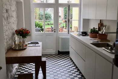 Geschlossene, Einzeilige, Große Moderne Küche ohne Insel mit Waschbecken, flächenbündigen Schrankfronten, weißen Schränken, Küchenrückwand in Weiß und weißer Arbeitsplatte in Köln