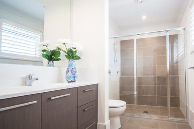 Inspiration for a mid-sized contemporary bathroom in Sydney with flat-panel cabinets, brown cabinets, white walls, an integrated sink, an alcove shower, a two-piece toilet, brown tile, ceramic tile, ceramic floors, brown floor and a sliding shower screen.