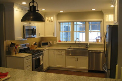 Kitchen - traditional dark wood floor kitchen idea in New York with a farmhouse sink, white cabinets, quartzite countertops, gray backsplash, glass tile backsplash and stainless steel appliances