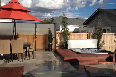 Large minimalist backyard patio fountain photo in Calgary with decking and a gazebo