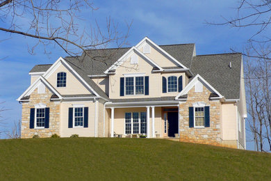 Inspiration for a large timeless beige two-story mixed siding exterior home remodel in Other