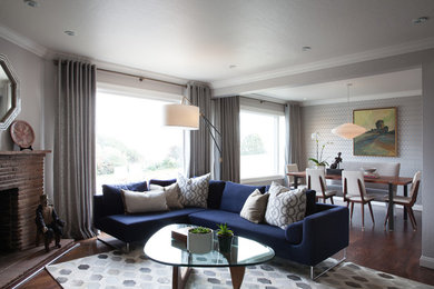 Inspiration for a small modern open concept medium tone wood floor living room remodel in San Francisco with gray walls, a corner fireplace, a brick fireplace and a wall-mounted tv