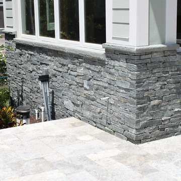 Florida Home with Stone Cladding, Sitting Walls, Outdoor Kitchen, and Fire Pit