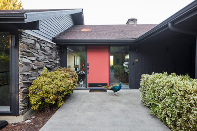 Diseño de fachada de casa negra vintage con revestimientos combinados y tejado de teja de madera