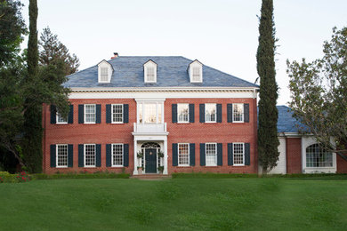 Example of a huge classic red two-story brick exterior home design in Los Angeles