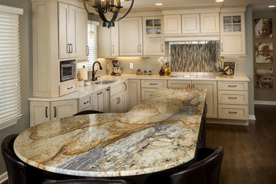 Example of a mid-sized transitional l-shaped dark wood floor eat-in kitchen design in Indianapolis with beige cabinets, granite countertops, beige backsplash, paneled appliances, an island, an undermount sink, shaker cabinets and ceramic backsplash