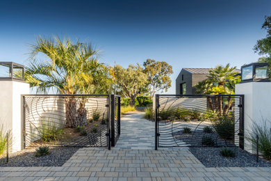 Photo of a modern front yard concrete paver and metal fence landscaping in Santa Barbara.