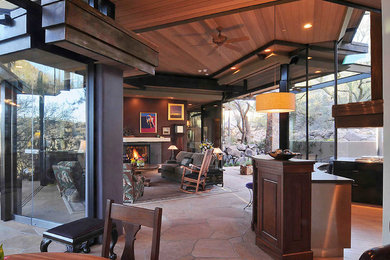 Contemporary open concept living room in Denver with a two-sided fireplace and a stone fireplace surround.