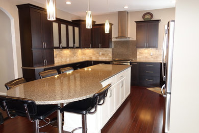 Mid-sized transitional u-shaped dark wood floor eat-in kitchen photo in Other with an undermount sink, recessed-panel cabinets, dark wood cabinets, quartzite countertops, beige backsplash, stone tile backsplash, stainless steel appliances and an island