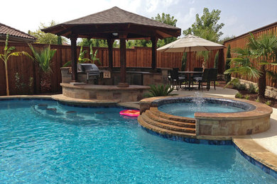 Example of a mid-sized southwest backyard custom-shaped and stone natural hot tub design in Dallas