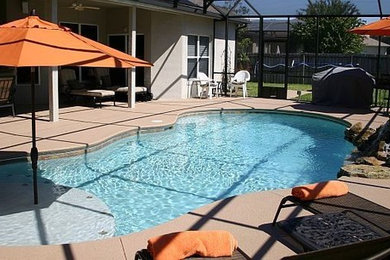 Example of a large backyard concrete and custom-shaped pool design in Orlando