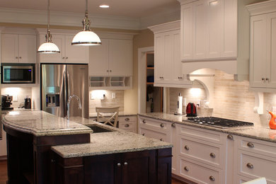 Inspiration for a large timeless l-shaped medium tone wood floor open concept kitchen remodel in Other with a single-bowl sink, flat-panel cabinets, white cabinets, granite countertops, beige backsplash, stone tile backsplash, stainless steel appliances and an island