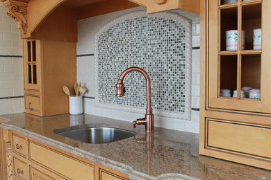 Small kitchen in New York with multi-coloured splashback and glass tile splashback.