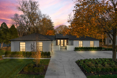 Idées déco pour une façade de maison blanche rétro en brique de plain-pied avec un toit à quatre pans et un toit noir.