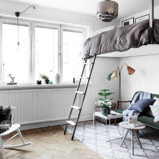 Foto di una camera da letto stile loft scandinava di medie dimensioni con pareti bianche e parquet chiaro