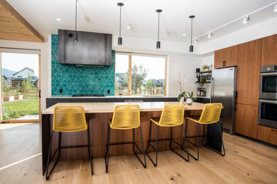 Mid-sized trendy l-shaped light wood floor and white floor open concept kitchen photo in Other with an undermount sink, flat-panel cabinets, gray cabinets, quartz countertops, blue backsplash, stone tile backsplash, stainless steel appliances, an island and white countertops