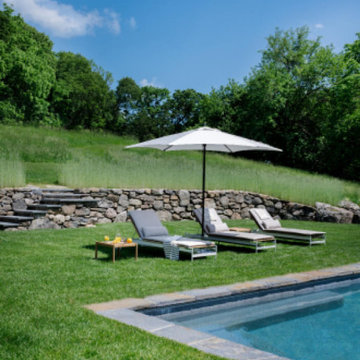 Modern Pool with Stone Surround and Wheeled Chaise Lounges