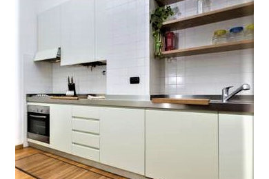 Idee per una cucina lineare moderna chiusa e di medie dimensioni con top in acciaio inossidabile