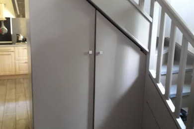 Exemple d'une petite buanderie tendance en U avec un placard, un placard avec porte à panneau encastré et des portes de placard grises.