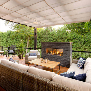 トロントのモダンスタイルのおしゃれな裏庭のデッキ (屋外暖炉、パーゴラ) の写真