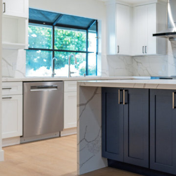 Modern White Shaker Kitchen with Navy Blue Island and Waterfall Quartz Counterto