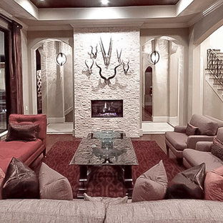 Großes, Repräsentatives, Fernseherloses, Offenes Mediterranes Wohnzimmer mit beiger Wandfarbe, braunem Holzboden, Tunnelkamin und Kaminsims aus Stein in Houston