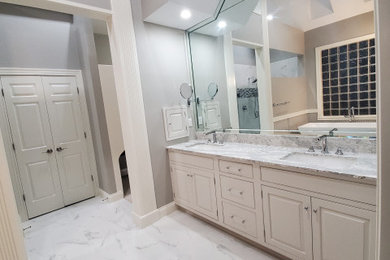 Bathroom - large modern master white tile and cement tile cement tile floor, white floor and double-sink bathroom idea in Indianapolis with raised-panel cabinets, white cabinets, a one-piece toilet, gray walls, an undermount sink, quartz countertops, a hinged shower door, white countertops, a niche and a built-in vanity