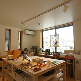 Design ideas for a medium sized modern home studio in Tokyo with white walls, vinyl flooring, a freestanding desk and beige floors.