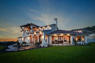Large tuscan beige two-story mixed siding exterior home photo in Austin