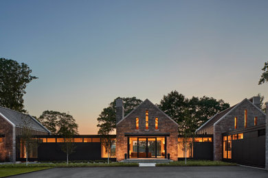 Huge minimalist gray two-story stone house exterior photo in Bridgeport with a metal roof and a gray roof