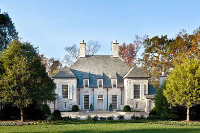 Example of a mid-sized classic gray two-story stone house exterior design in Charlotte with a hip roof and a shingle roof