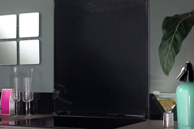 Foto de cocina contemporánea con armarios con paneles lisos, puertas de armario negras, salpicadero negro y salpicadero de vidrio templado