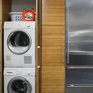 Photo of a modern laundry cupboard in Austin with a concealed washer and dryer.