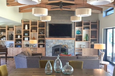 Photo of a large country open plan dining in Sacramento with white walls, medium hardwood floors, a standard fireplace, a stone fireplace surround and brown floor.