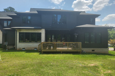Example of a large trendy backyard patio design in Charlotte with a roof extension