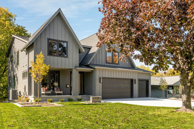 Transitional gray two-story board and batten house exterior photo in Minneapolis with a shingle roof and a black roof