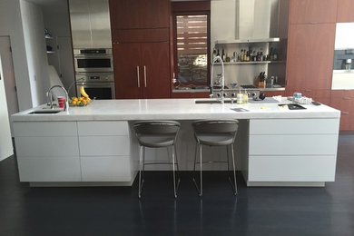 Open concept kitchen - large contemporary l-shaped concrete floor open concept kitchen idea in DC Metro with an undermount sink, flat-panel cabinets, dark wood cabinets, marble countertops, metallic backsplash, stainless steel appliances and an island