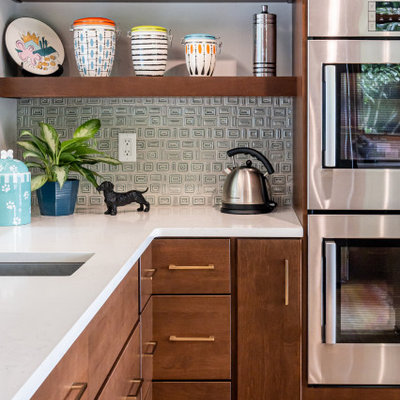 Example of a mid-sized mid-century modern u-shaped light wood floor, beige floor and exposed beam kitchen design in Other with a single-bowl sink, flat-panel cabinets, medium tone wood cabinets, quartzite countertops, green backsplash, porcelain backsplash, stainless steel appliances, an island and white countertops