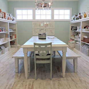 Photo of a mid-sized beach style craft room in Raleigh with blue walls, vinyl floors, no fireplace and a freestanding desk.