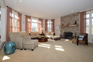 Example of a large trendy enclosed carpeted family room design in Philadelphia with beige walls, a standard fireplace, a stone fireplace and no tv