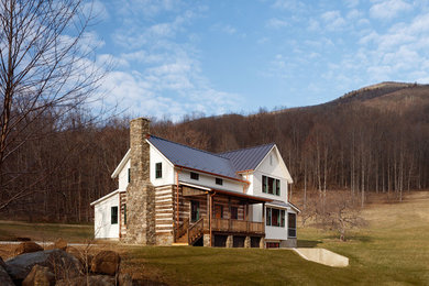 Large farmhouse white split-level wood exterior home photo in Other with a metal roof