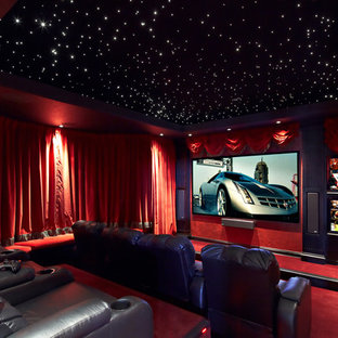 Photo of a large mediterranean enclosed home cinema in New Orleans with red walls, carpet, red floors and a projector screen.
